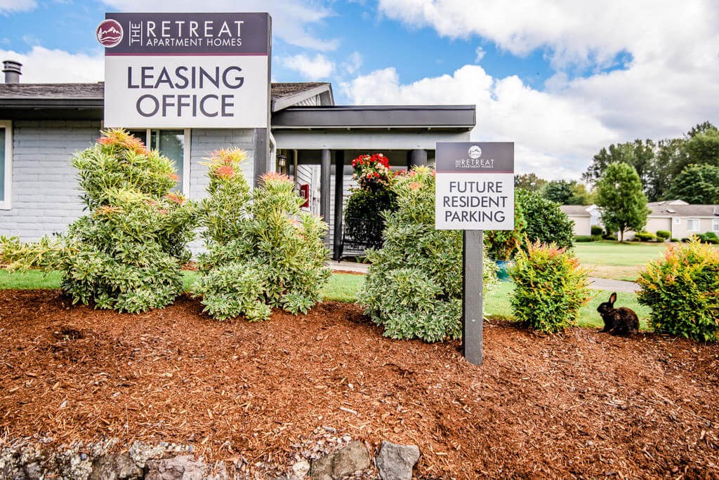 A sign for a leasing office and future resident parking in front of a building. at The Retreat, Sumner, Washington