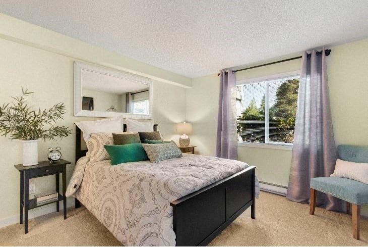 A bedroom with a large bed and a chair. at The Retreat, Sumner