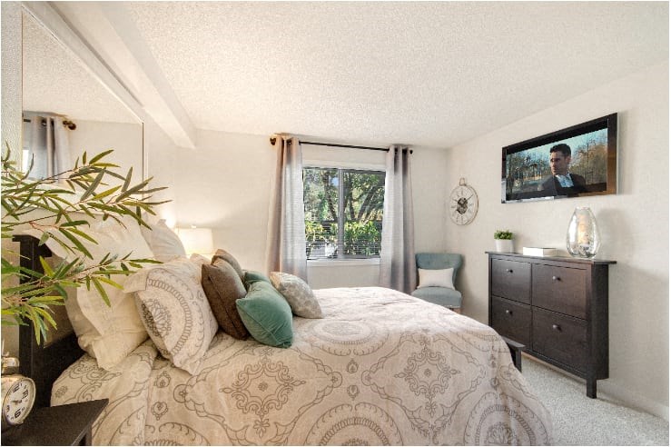 A bedroom with a large bed and a painting of a man on the wall. at The Retreat, Washington