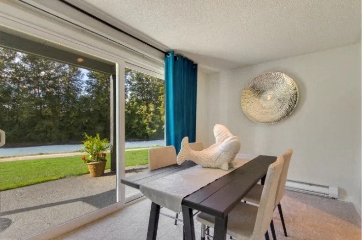 A dining room with a table and chairs and a view of the outdoors. at The Retreat, Washington, 98390