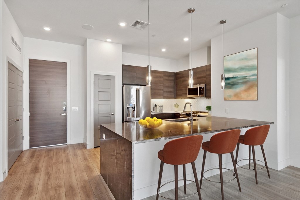 a kitchen with an island with three stools