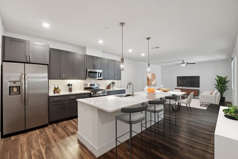 a kitchen and living room with a large island and stainless steel appliances