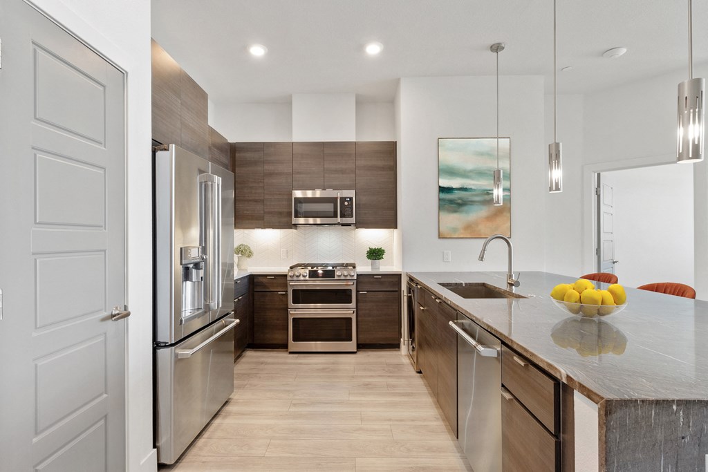 a modern kitchen with stainless steel appliances and a counter top