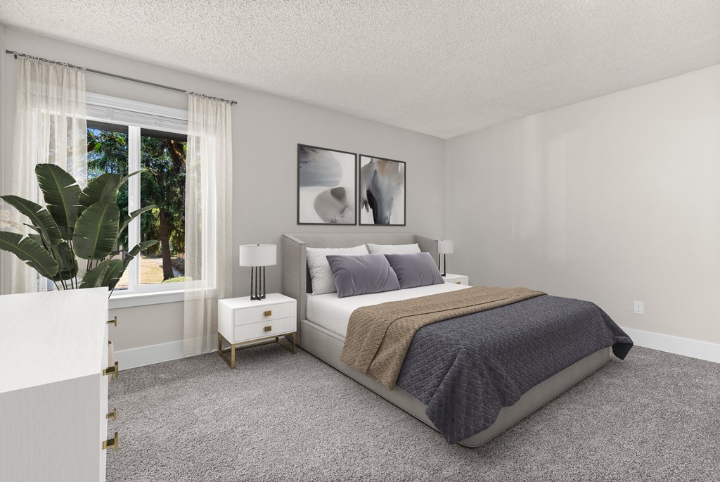 A bedroom with a large bed and a potted plant.