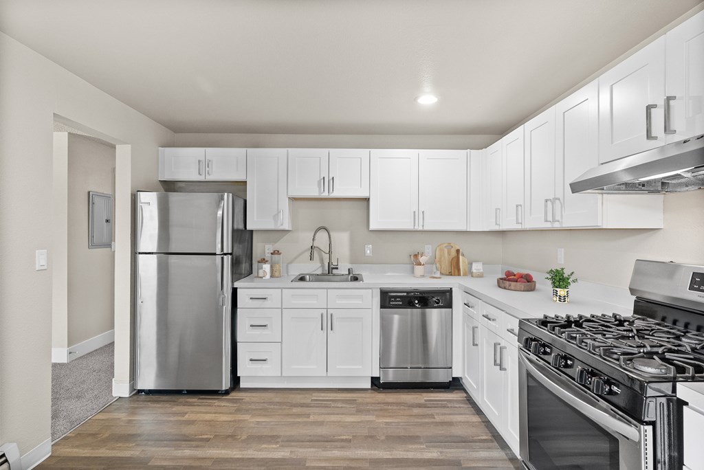A modern kitchen with white cabinets and stainless steel appliances.