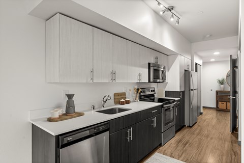 A modern kitchen with dark wood cabinets and stainless steel appliances.