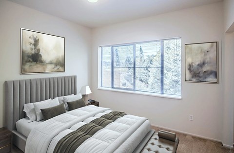 A bedroom with a large bed and two framed pictures on the wall.
