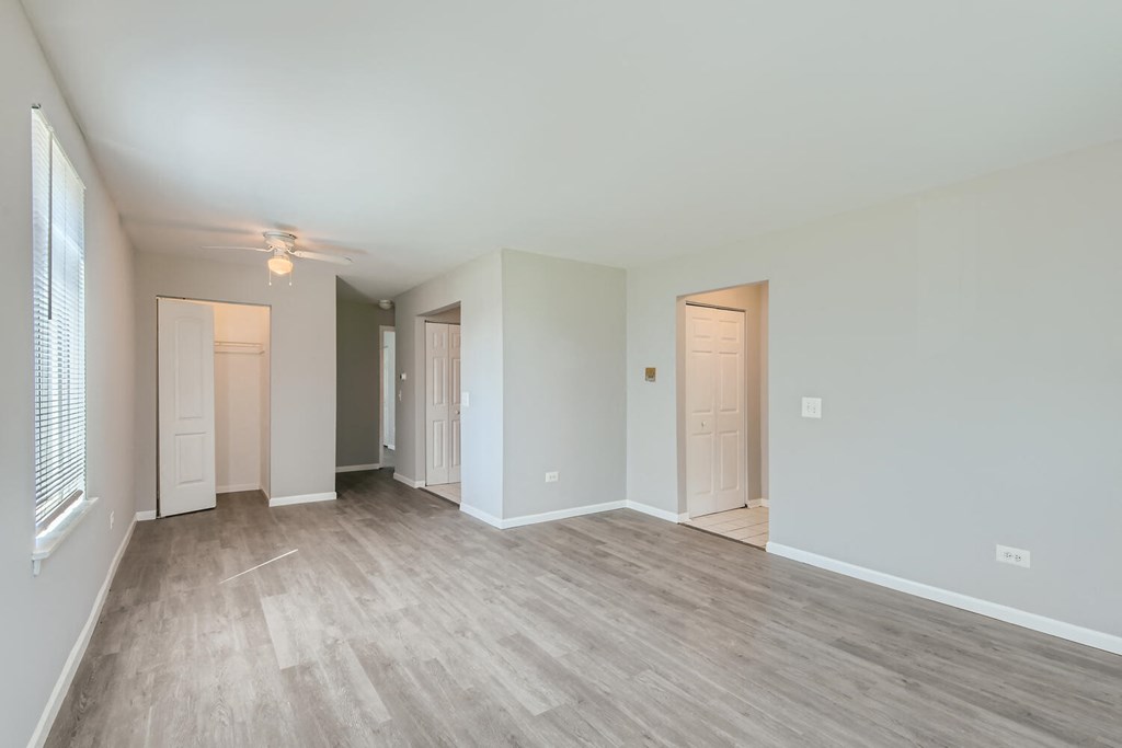 the living room and dining room of an empty home with wood flooring
