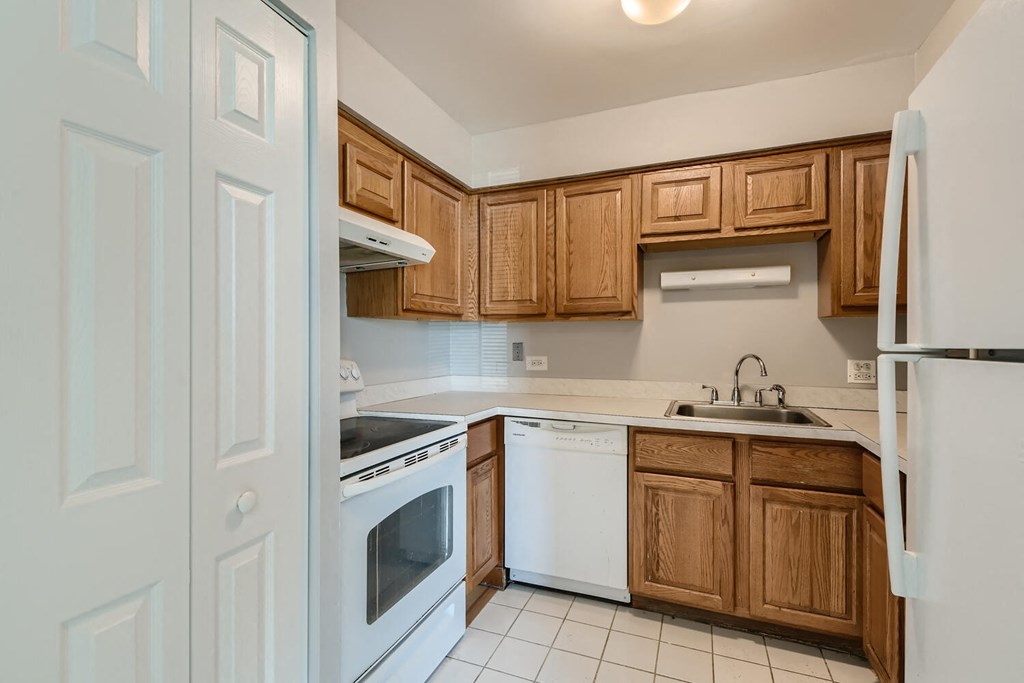 a kitchen with white appliances and wooden cabinets