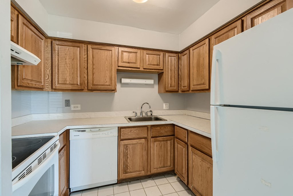 a kitchen with white appliances and wooden cabinets