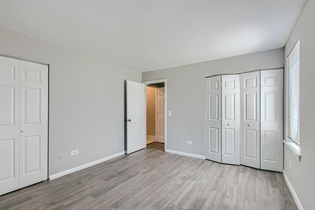 the living room of a new home with white doors and wood floors