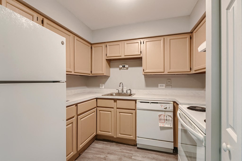 a kitchen with white appliances and wooden cabinets