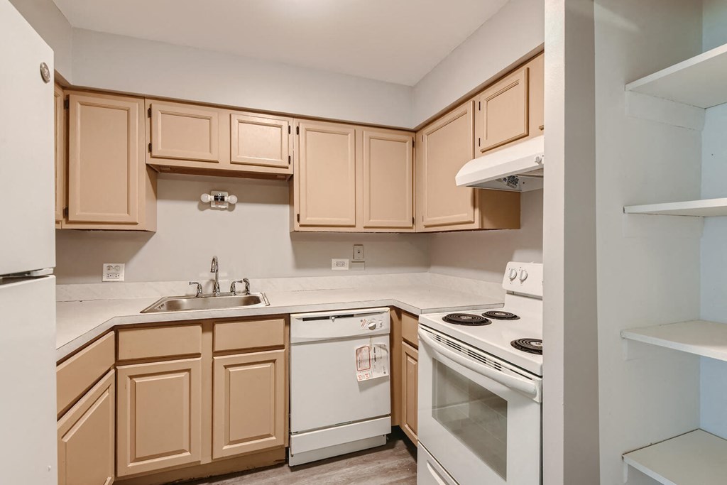 a kitchen with white appliances and wooden cabinets