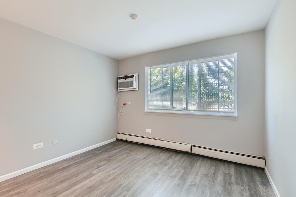 an empty room with wood floors and a window
