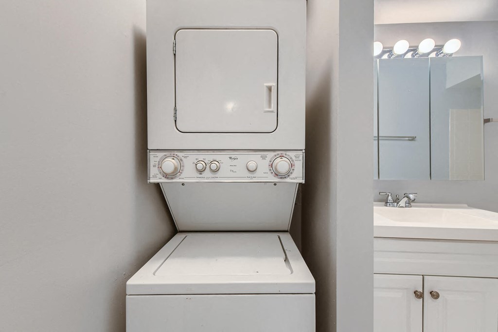 a white washer and dryer in a laundry room with a sink