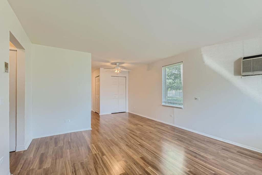 a living room with a hard wood floor and a window