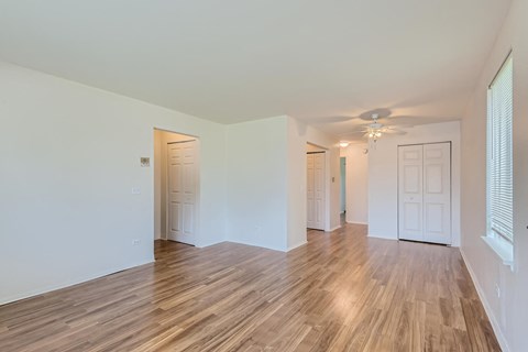 a living room with a hard wood floor and a ceiling fan