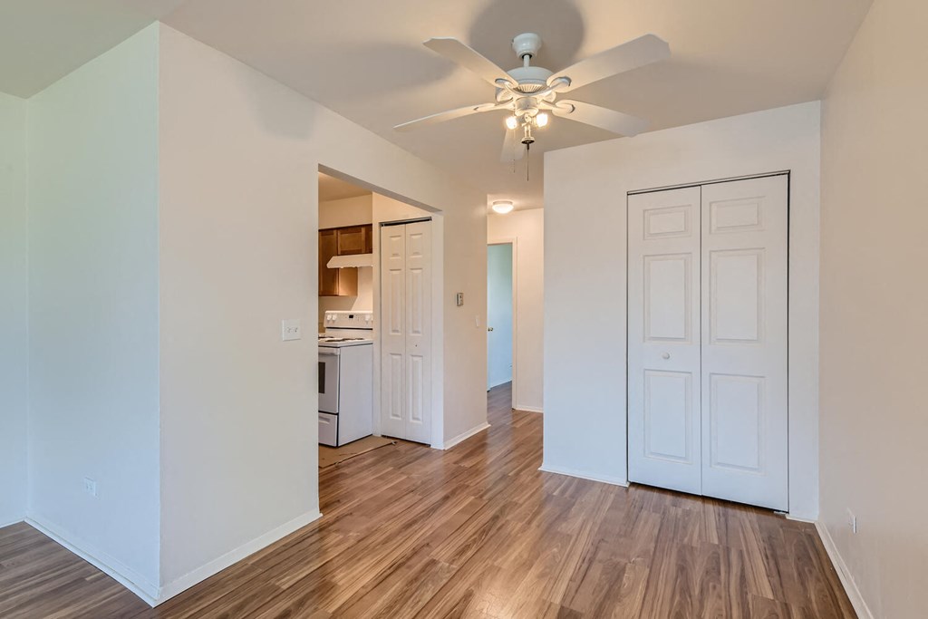 a living room with a ceiling fan and a kitchen