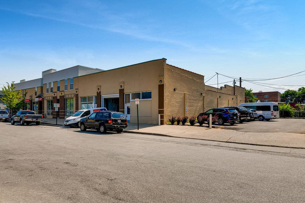 a building on the corner of a street with parked cars