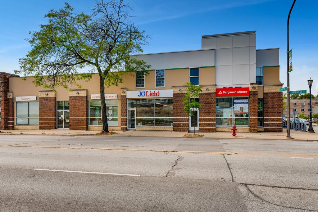 the front of a mall with a red fire hydrant on the street