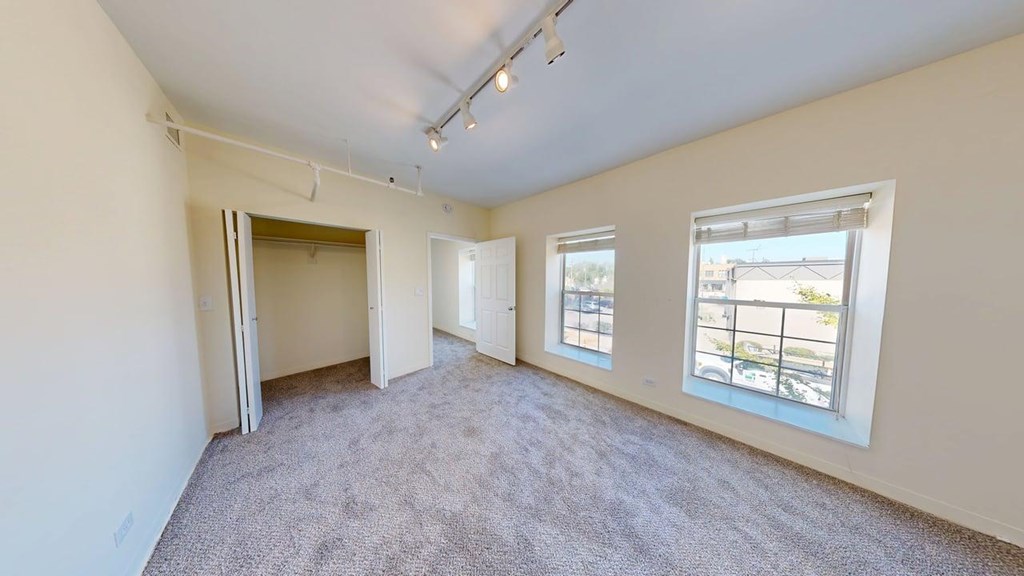 Empty room with carpeted floor and white walls.