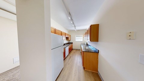 A kitchen with white cabinets and a white fridge.