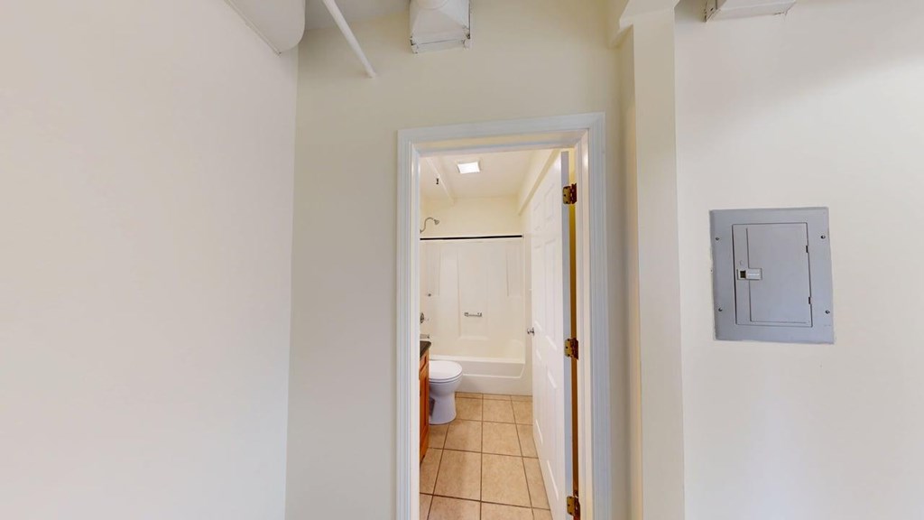 A bathroom with a toilet and a sink is visible through an open door.