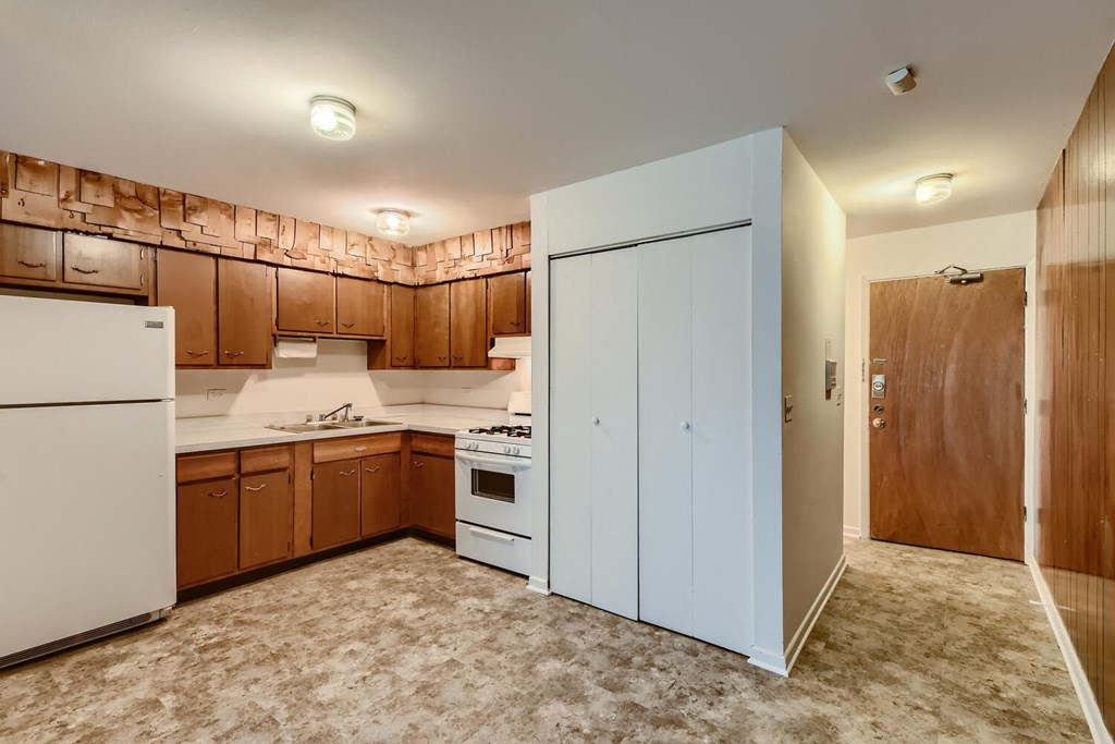 a kitchen with white appliances and wooden cabinets