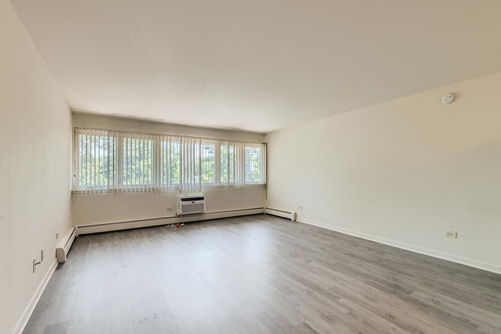an empty living room with white walls and wood floors
