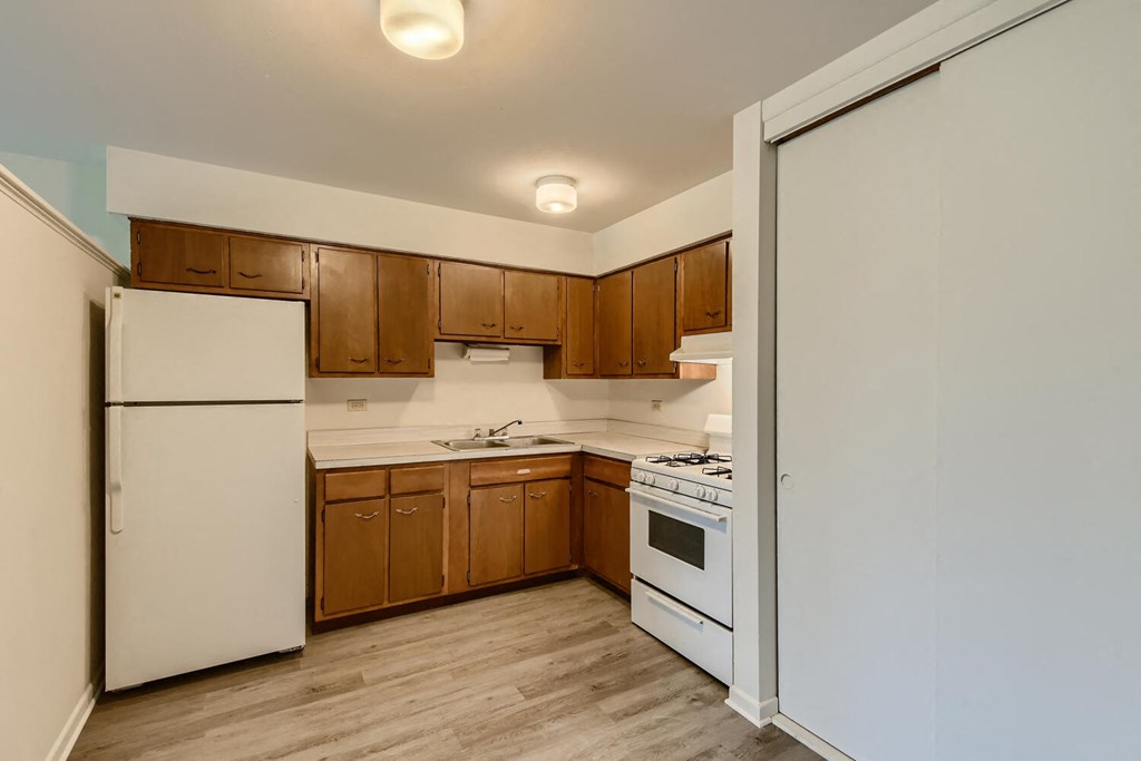 a kitchen with white appliances and wooden cabinets