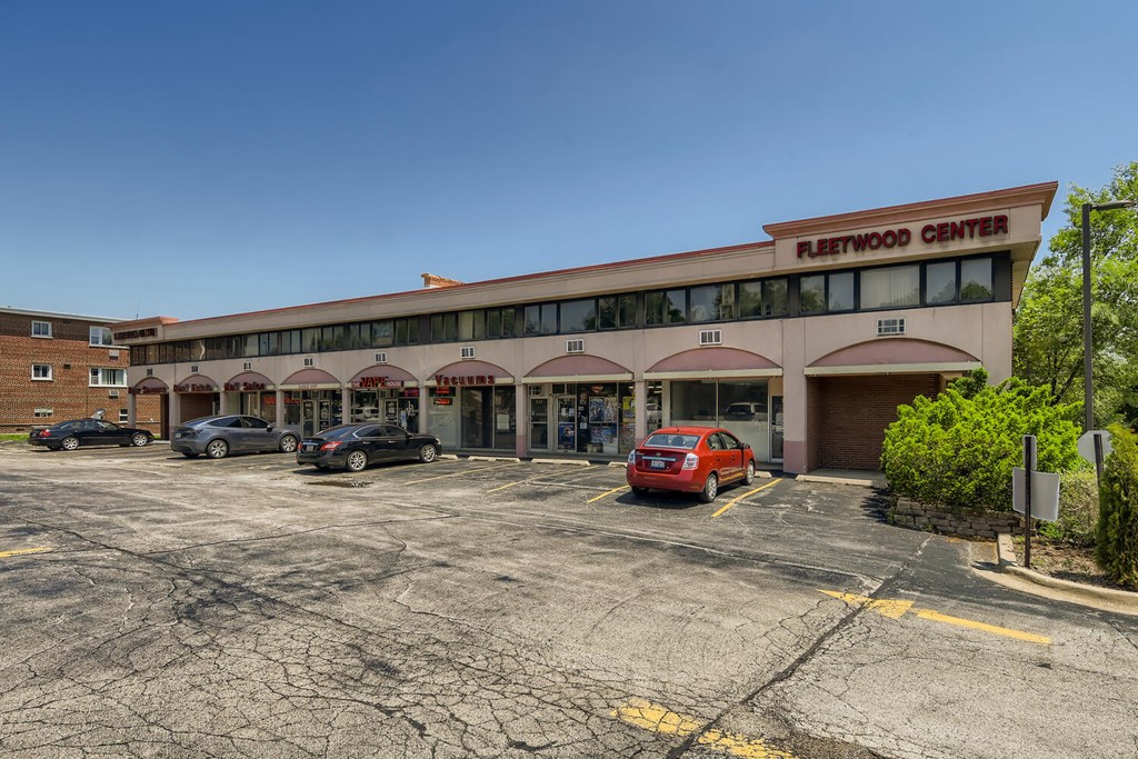 a building with a parking lot with cars in front of it