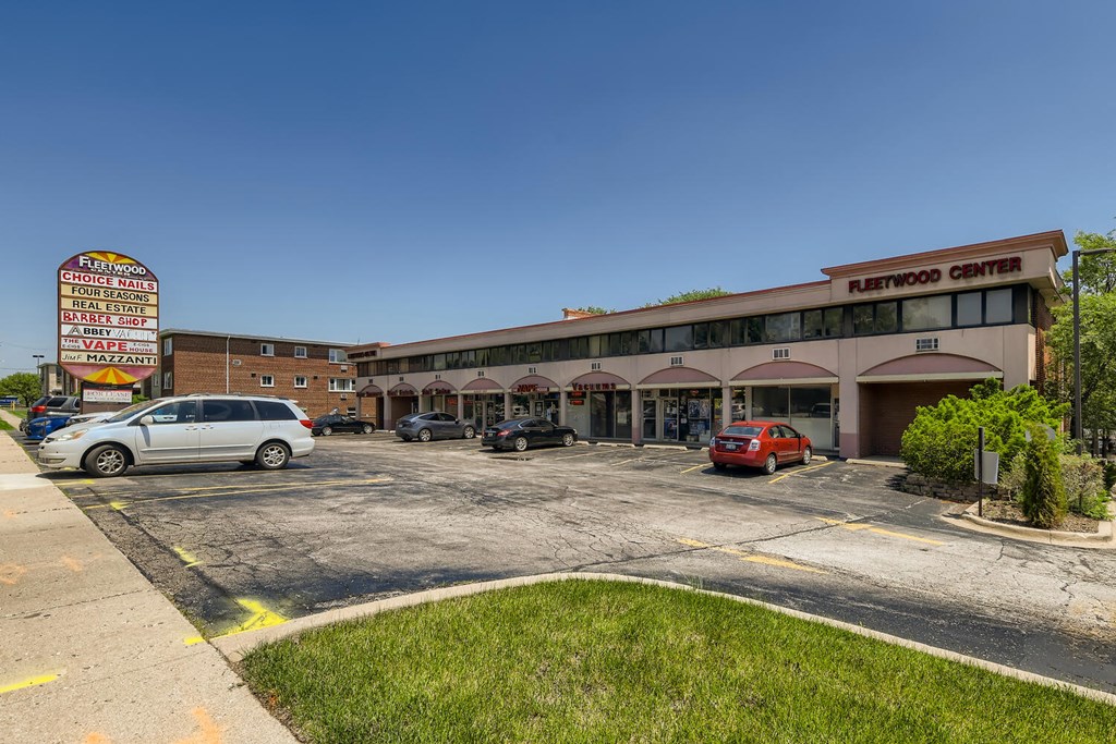 a parking lot in front of a shopping center with a building