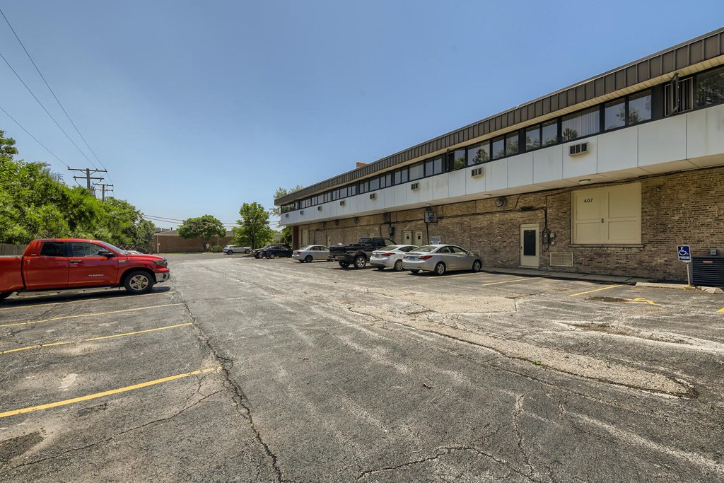 a parking lot in front of a building with cars parked