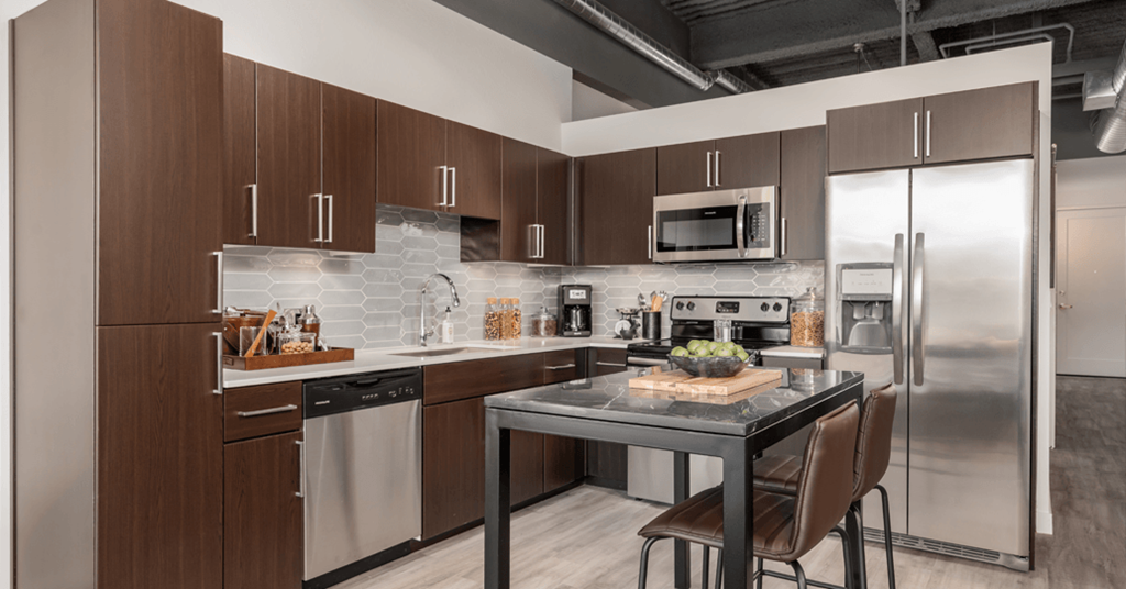 a kitchen with stainless steel appliances and a marble counter top