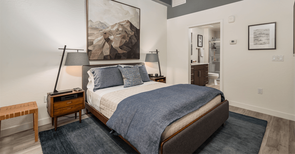 a bedroom with a bed and a painting on the wall