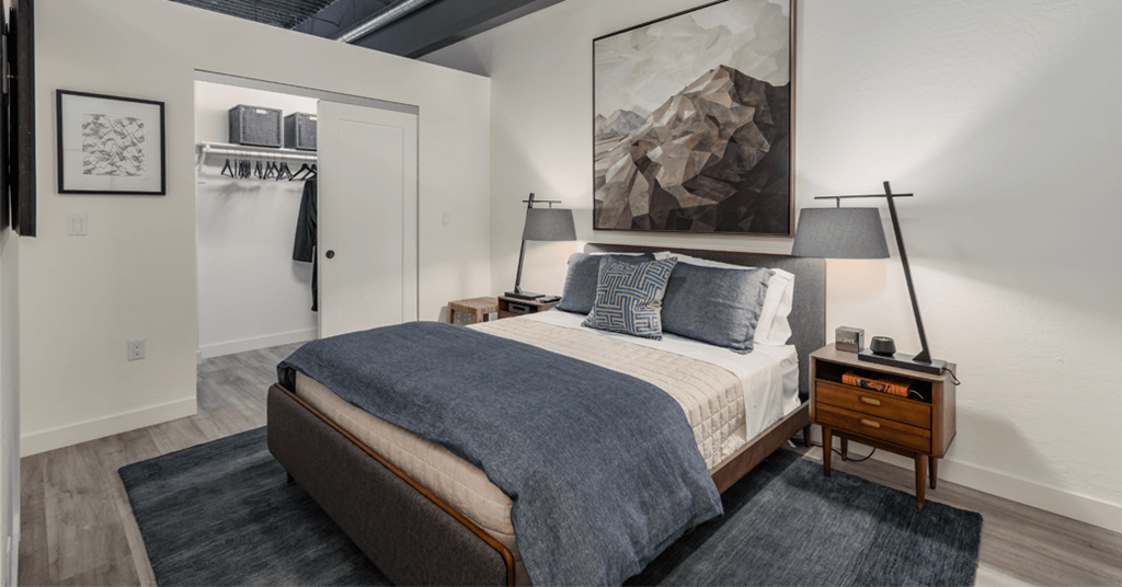 a bedroom with a bed and a painting on the wall