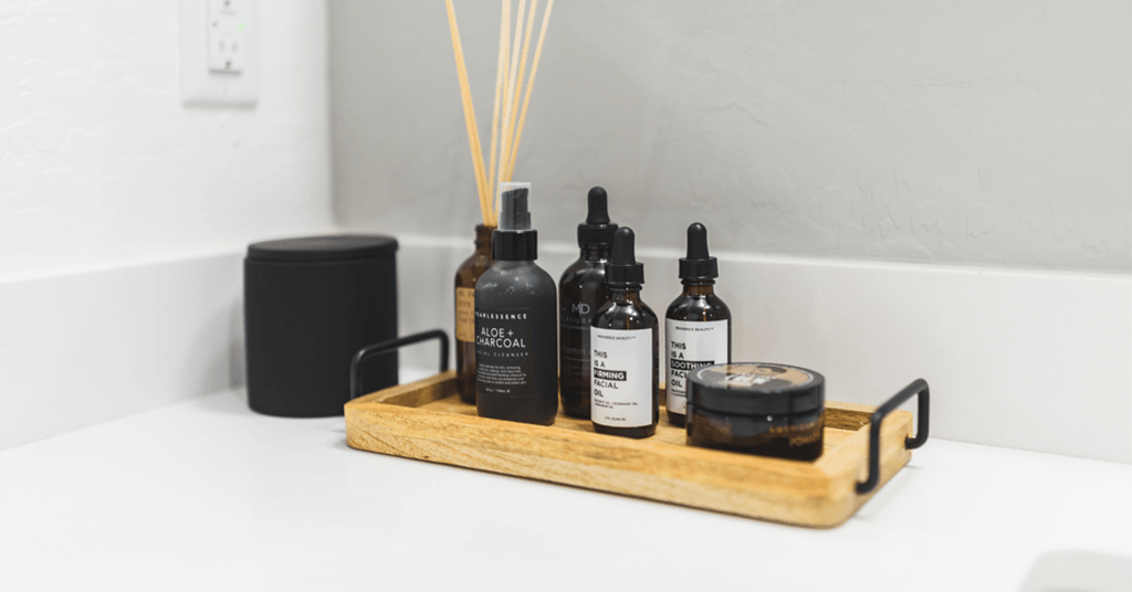 a tray with various bottles of oils and perfume on a bathroom counter