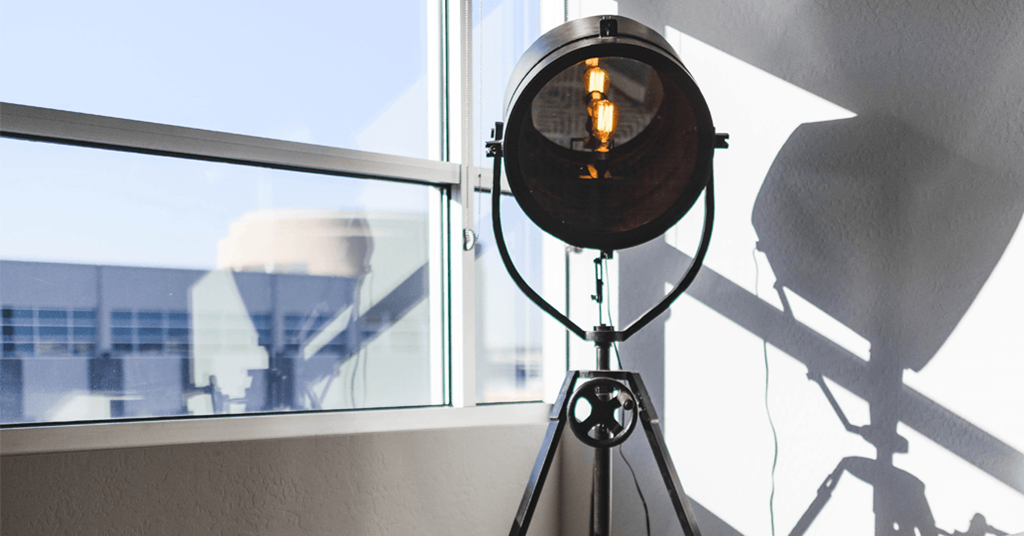 a light on a tripod in front of a window