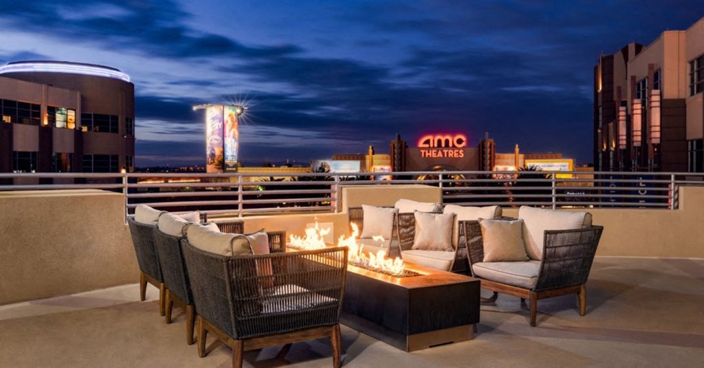 a rooftop fire pit with a view of the city at night