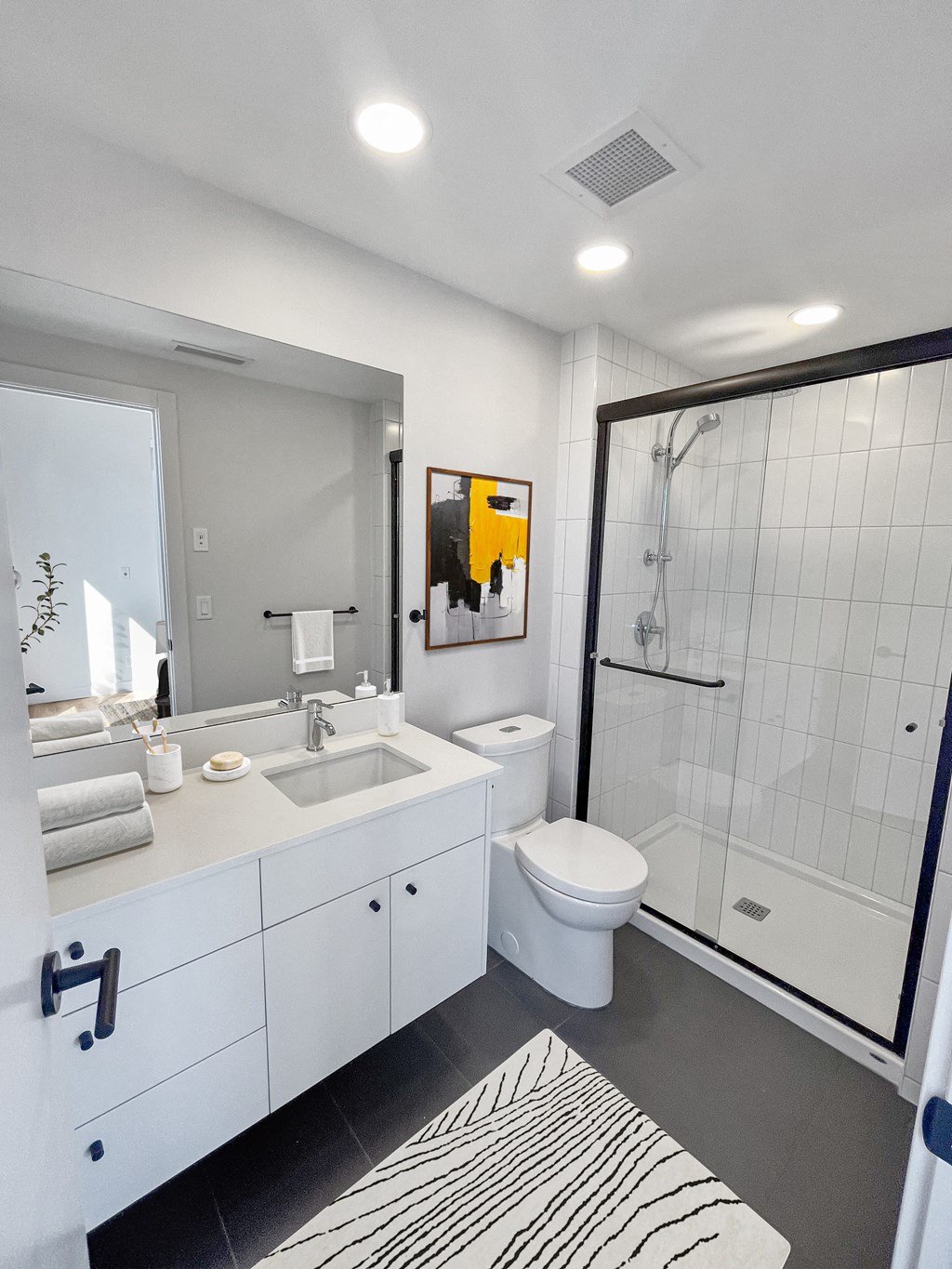 a white bathroom with a shower toilet and sink