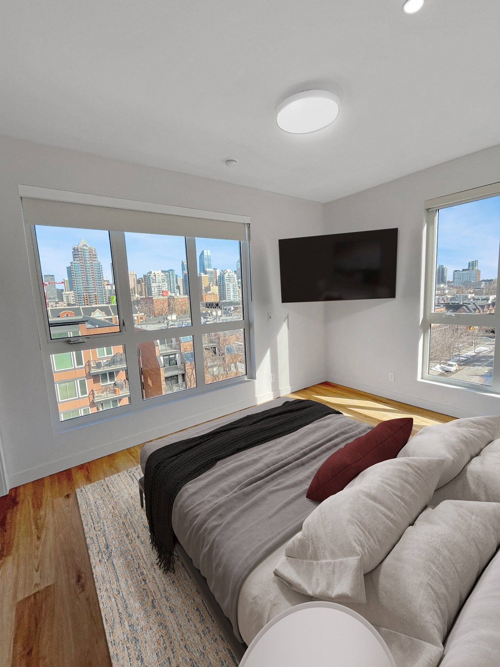 a bedroom with a bed and a large window and a tv