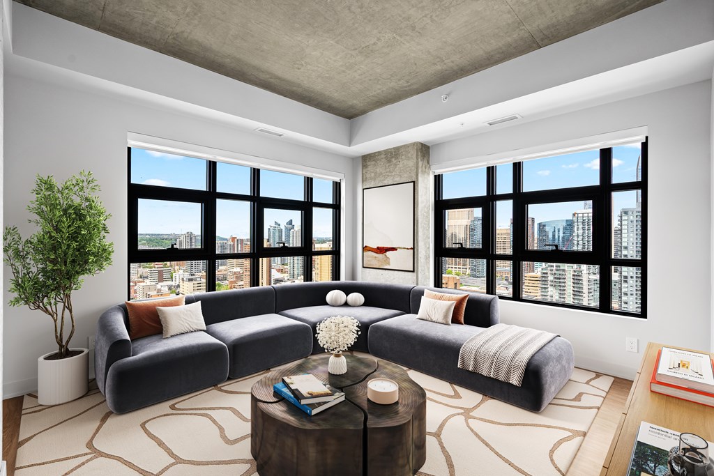 Suite 2502 - A living room with a large sectional sofa and a coffee table in front of a large window.