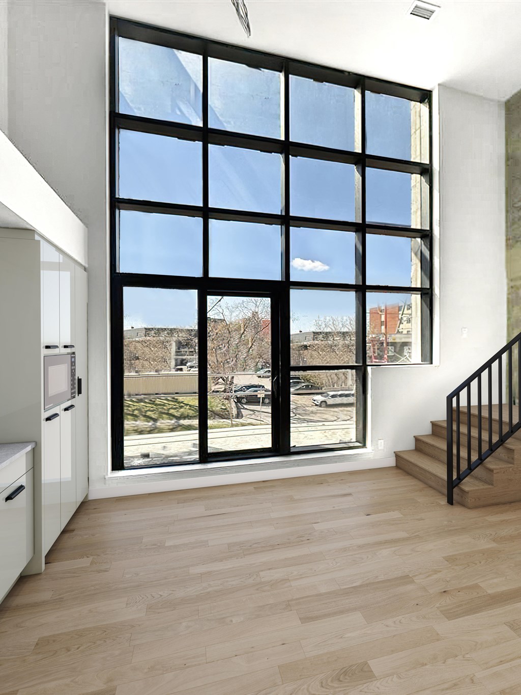 A kitchen with a large window overlooking a parking lot.