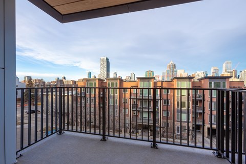 A balcony with a metal railing overlooks a cityscape.