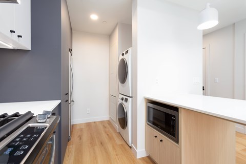 A modern kitchen with a white countertop and a microwave oven.