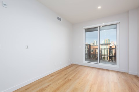 Empty room with a window overlooking a cityscape.