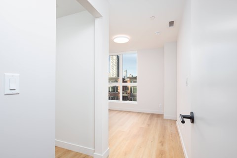 A white room with a door leading to a balcony.