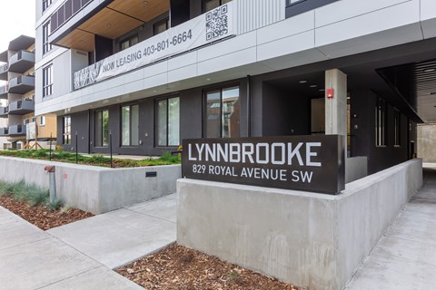 A Lynnbrooke building with a sign that says "Now Leasing" and a phone number.