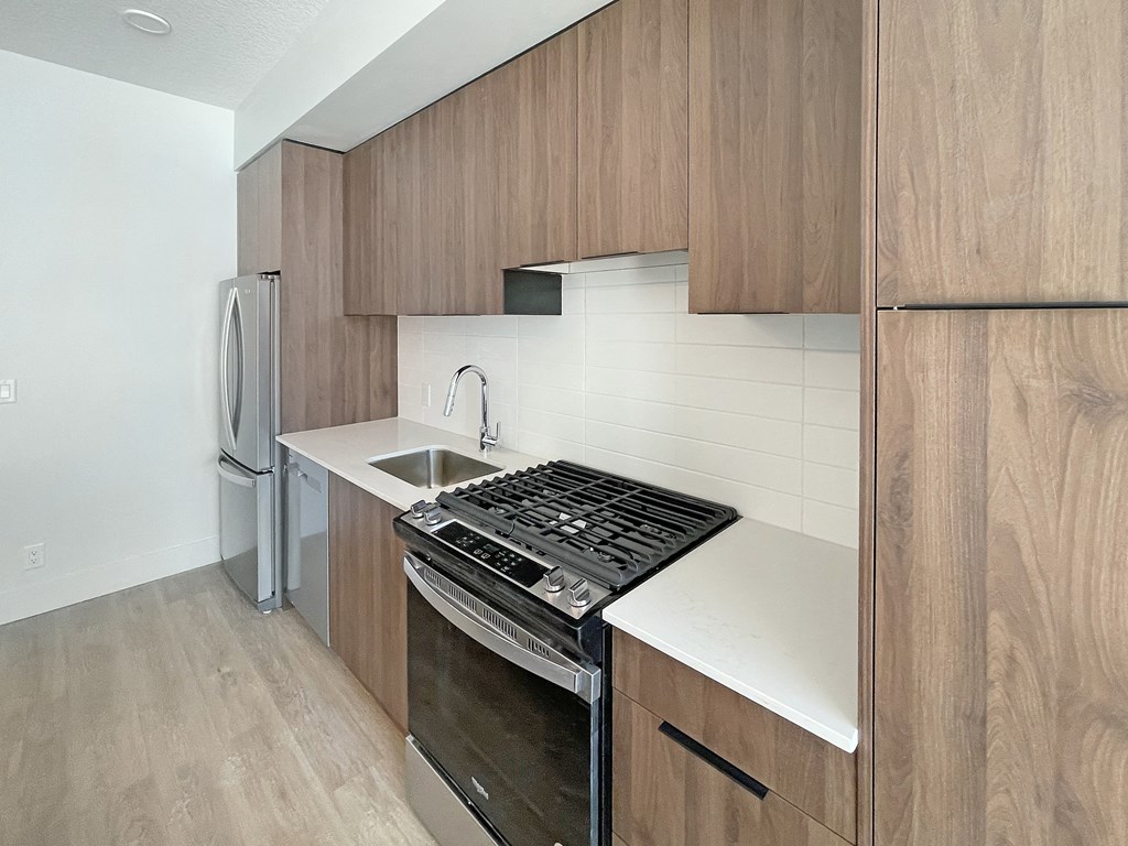 a kitchen with wooden cabinets and a stove and a sink