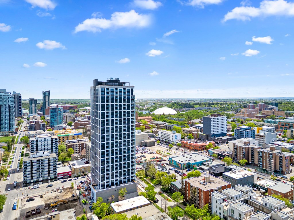A cityscape with a tall building in the foreground and other buildings in the background.